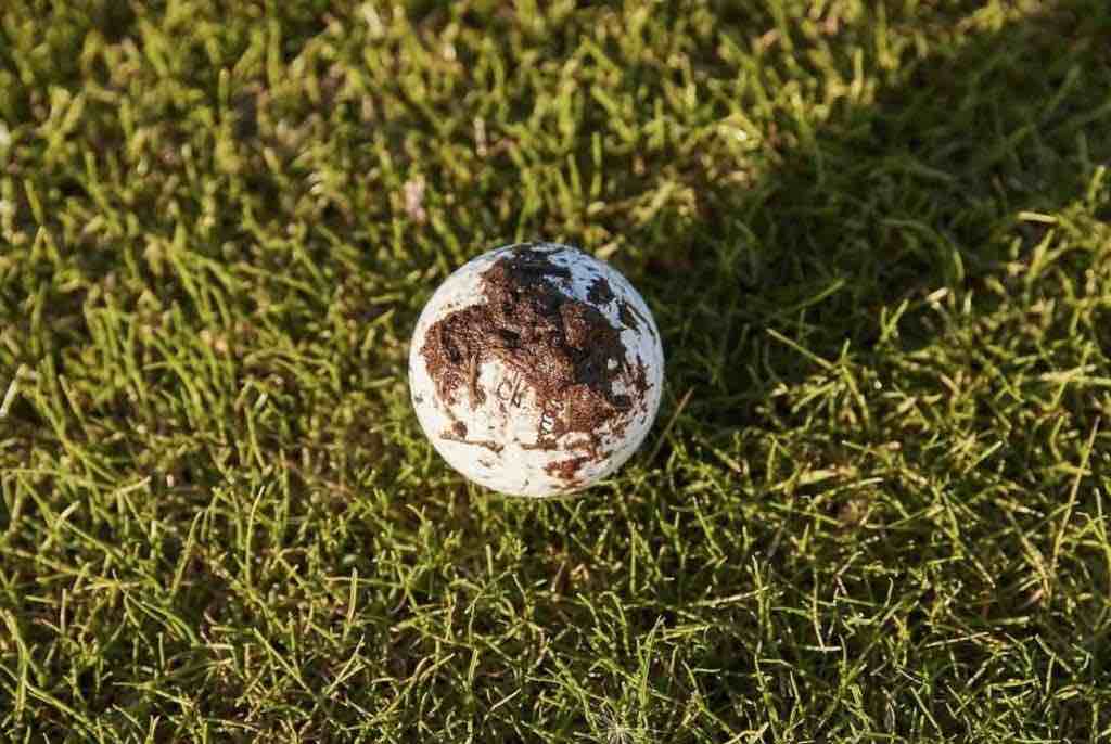 golf ball with mud on the grass