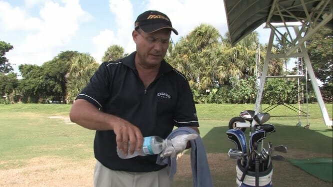 man washing his golf glove with mineral bottled water