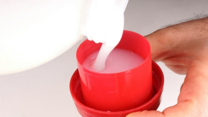 pouring cleaning subtance in a red cup