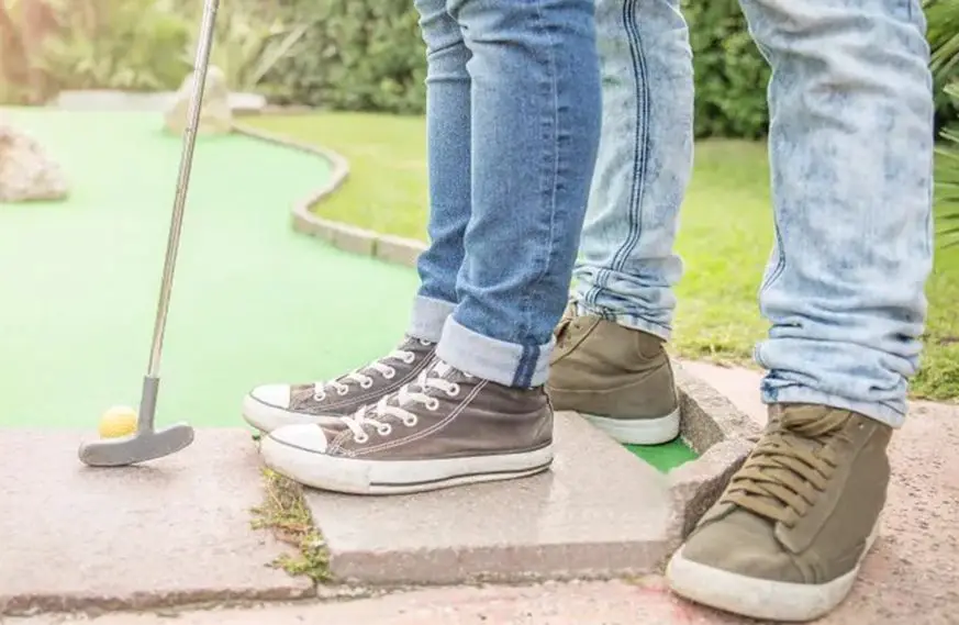 man and woman playing mini golf