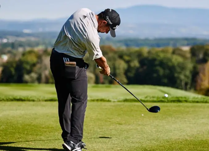 man on the golf course smashing the golf ball