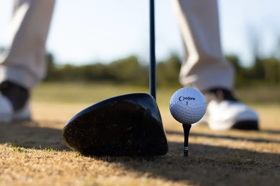 man preparing to hit golf balls at the golf course