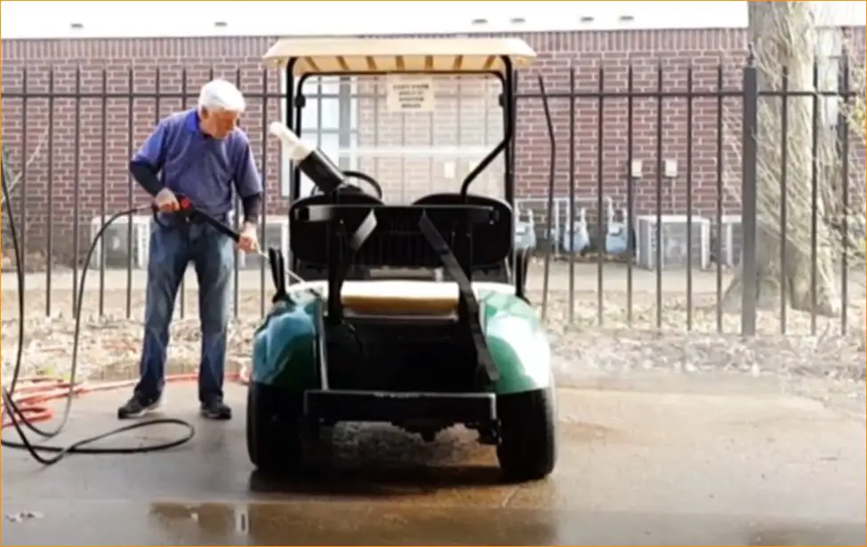 man cleaning his Yamaha Gas Golf Cart