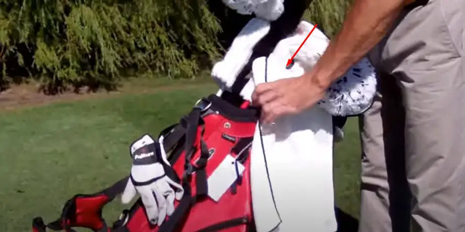 man showing where the hole on the golf towel